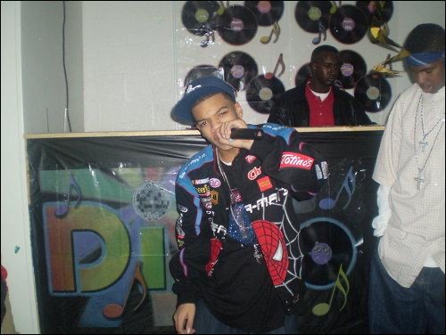 Artist performing live on the mic at Dis Li Spot